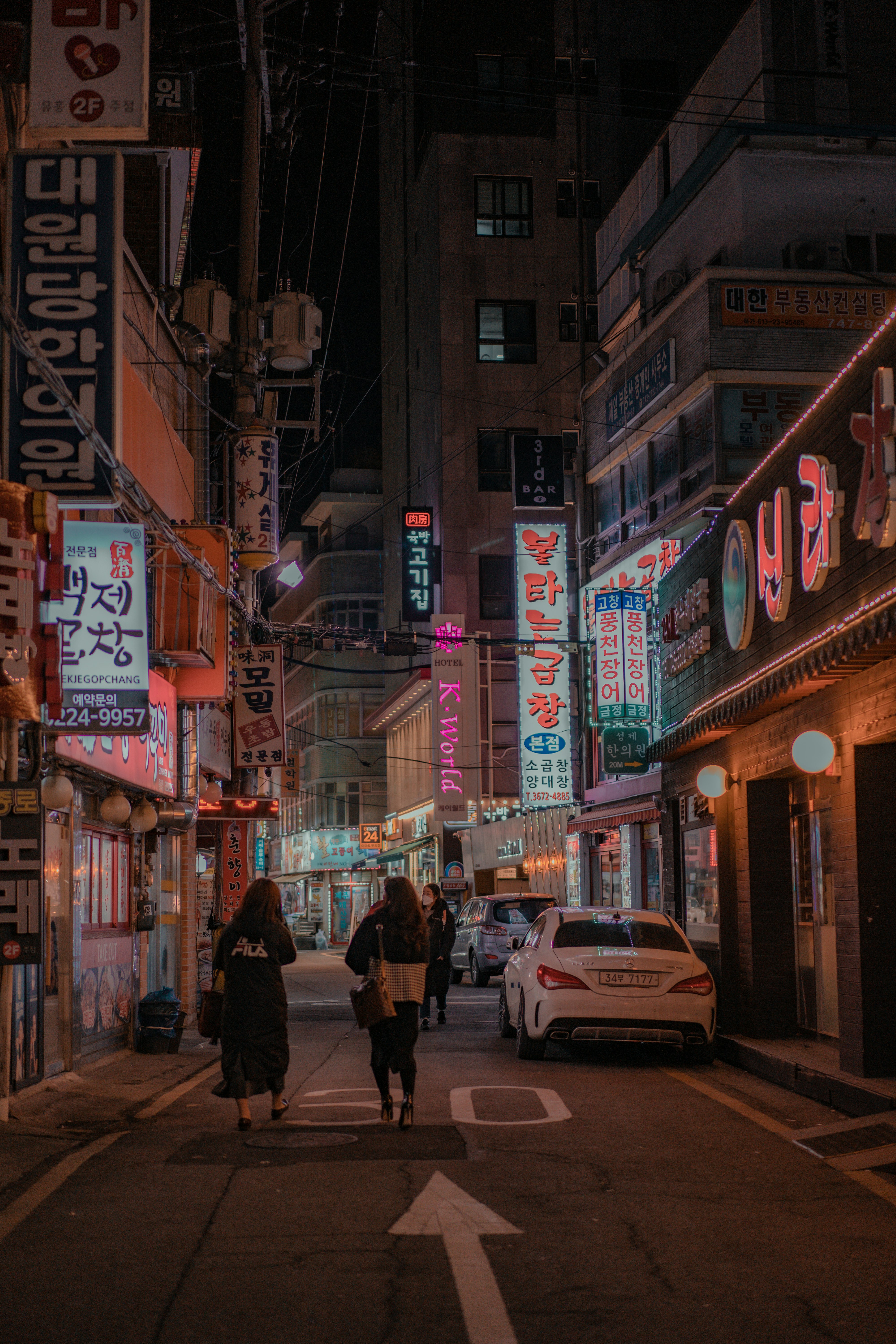 people walking on sidewalk during night time